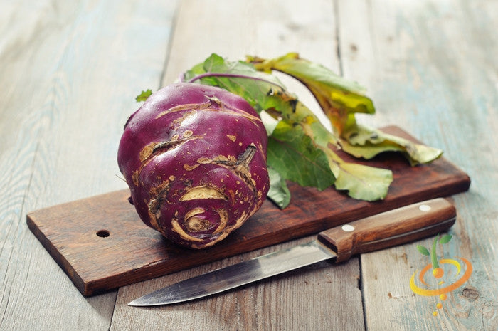 Kohlrabi Vienna purple bulb with leaves on wooden board next to knife