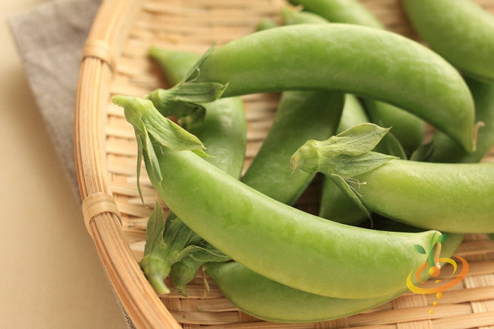 Close-up of fresh green sugar snap peas in a woven basket for Sugar Snap seeds