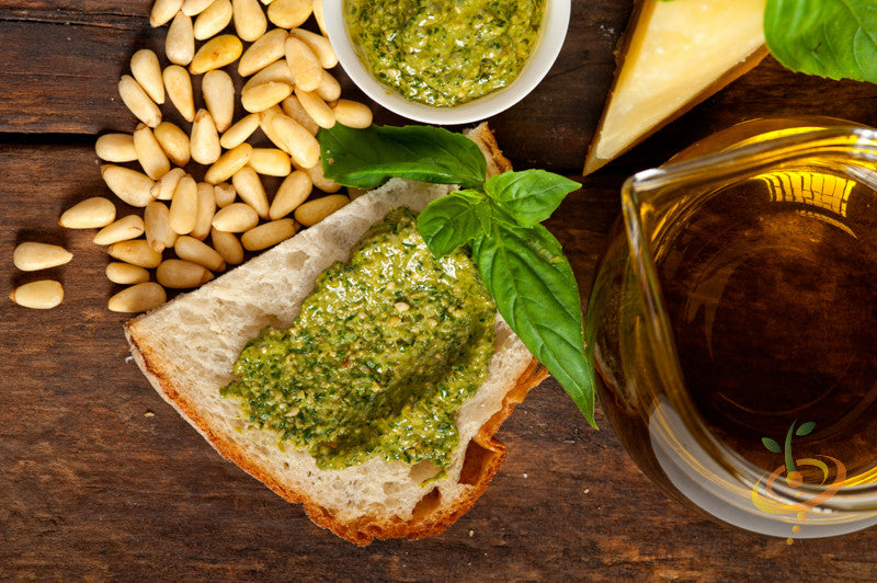 Italian Large Leaf Basil pesto spread on bread with pine nuts, cheese, and olive oil on wooden surface